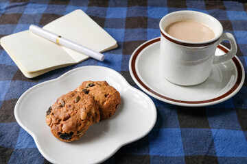 Coffee with Milk, Cookies, and Notebook on Checkered Tablecloth