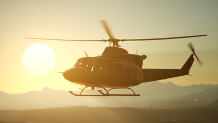 A helicopter ascends gracefully against a vibrant golden sunset, casting silhouettes on a rugged landscape. The tranquil evening sky enhances the beauty of this aerial scene.