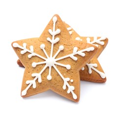 Two star-shaped gingerbread cookies decorated with white icing snowflakes