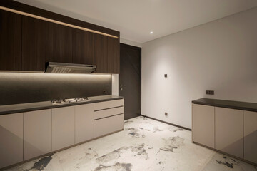 Wide view of a spacious, modern minimalist kitchen with two-tone cabinets and a unique marbled...