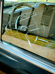 Steering Wheel of a Vintage Car Through a Window