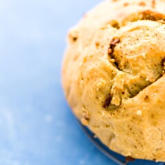 Close-up of a golden-brown, sweet bread roll, likely with nuts