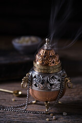 Incense burner with frankincense resin on wooden table – moody style