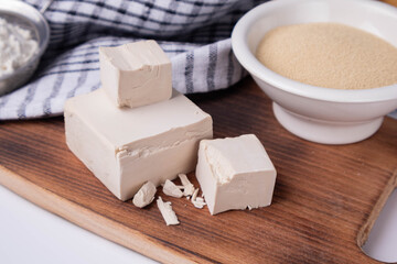 dry and compressed yeast on a wooden board