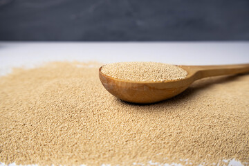 Dry yeast on wooden spoon — baking ingredient