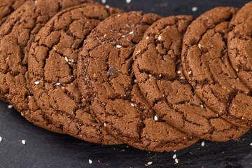 sweet chocolate biscuits on the kitchen table, chocolate biscuits with cocoa and sesame , close up