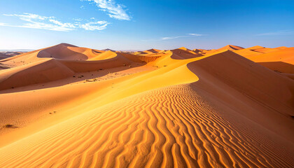 Golden sand dunes stretch across a vast desert landscape under a bright blue sky, showcasing intricate ripples and shadows.