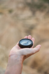 Close-up of hand holding compass in natural setting. Lifestyle. Hiking. Bardenas Reales.