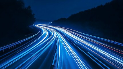Obraz premium Dark Night Highway Blurred Car Light Trails and Forest Scenery with a Blue Tone