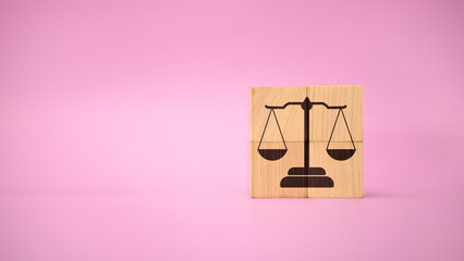 Law and Justice Balance Scale Symbol on Wooden Blocks with Pink Background