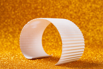 a white corrugated arch stands upright against a sparkling golden background © Freer