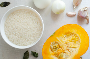 Ingredients for cooking pumpkin risotto: rice, pumpkin, onion, garlic. Cooking process. Concept Italian dish. Autumn food. Selective focus. Horizontal orientation. Top view