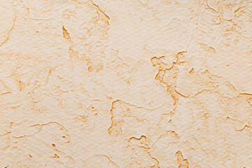 Wallpaper with a plaster texture covering uneven concrete in beige tones
