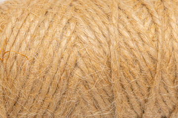 Jute thread wound on a cylindrical spool on a white background