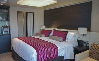 Doppelbett mit Dekokissen vor Schiebetür in Balkonkabine auf Kreuzfahrtschiff - Modern interior...