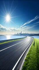 A wide, curving road follows the coastline towards a distant city skyline under a brilliant sunny blue sky with fluffy clouds.