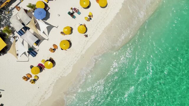 yellow beach umbrellas on the seashore, beach holiday top view