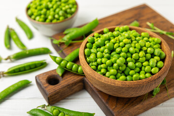 Fresh green pea pods with green peas on a wooden background. Sweet green peas. Green pea beans vegetables. Vegan. healthy vegetable. Copy space