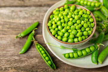Fresh green pea pods with green peas on a wooden background. Sweet green peas. Green pea beans vegetables. Vegan. healthy vegetable. Copy space
