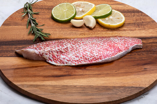 raw snapper fillet on wooden table
