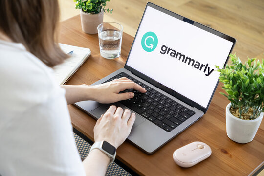 Poznan, Poland - August 23, 2025: Grammarly application on laptop screen, person typing, using digital tool for enhanced writing, grammar, and professional communication