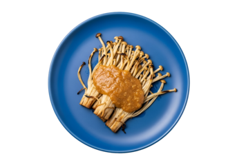 A vibrant display of grilled enoki mushrooms, glistening with a savory sauce, presented on a striking blue plate.