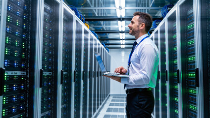 Fototapeta premium Male engineer working on a laptop in a data center