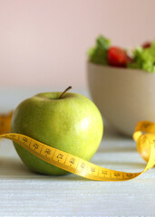 tape and lettuce on a light background. Slimming, diet, healthy food.. Vertical photo format