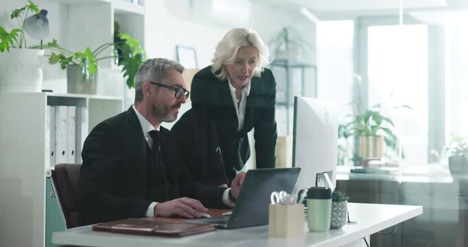 Help, laptop and business people in office, conversation and financial agency with cooperation. Employees, man and woman with feedback, computer and research for investment deal, discussion and audit