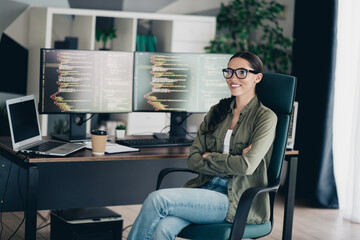 Professional software developer working remotely in her stylish home office with dual monitors showcasing programming code