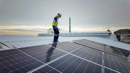 Solar panel installation on a rooftop by a technician during early evening