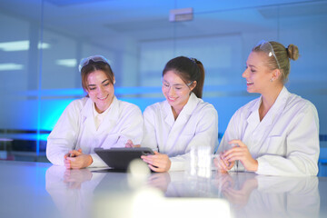 Group of women scientists discussing research in a modern laboratory during afternoon hours