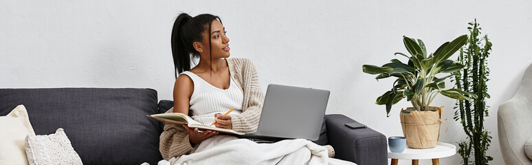 Relaxing at home, a young woman enjoys her cozy time while studying and sketching ideas