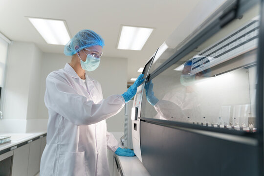 Laboratory technician operates advanced equipment during research process in modern facility
