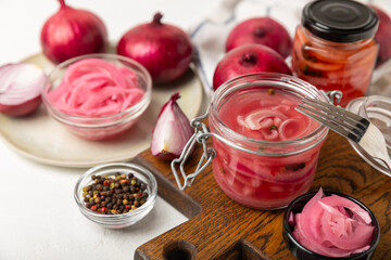 Pickled onions in a glass jar on the table. pickled red onion. Vegetarian spicy dish. Delicious homemade marinated pickled purple onions . Space for text. Copy space.