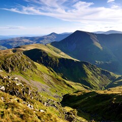 Fototapeta premium Mountain range, valley, rolling hills, lush green, rocky peaks, sunny day, expansive view
