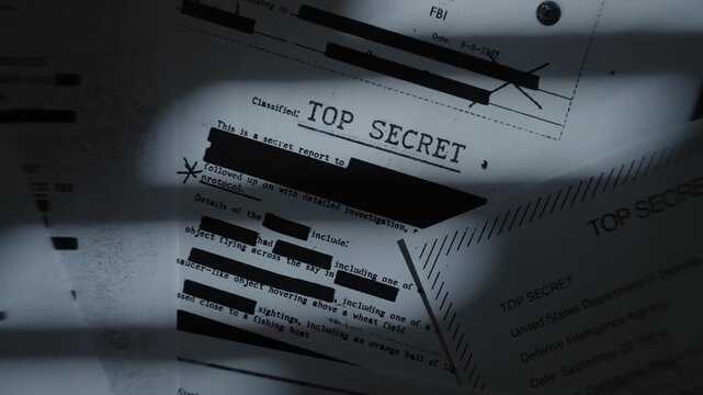 Stack of classified top secret documents and reports as camera pull up and spin. Secret files and government sensitive data and censored text laid out on desk with window shadow in dark office room