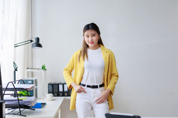 Young asia businesswoman standing in modern office looking confident