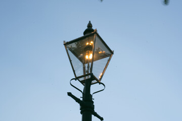 A street light with a bird flying in the background