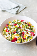 Pasta salad with tomatoes, zucchini, corn and feta cheese. Healthy eating. Vegetarian food.