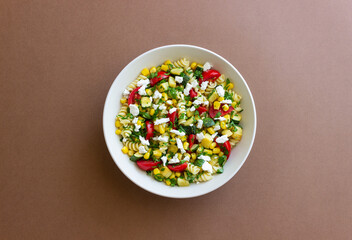 Pasta salad with tomatoes, zucchini, corn and feta cheese. Healthy eating. Vegetarian food.