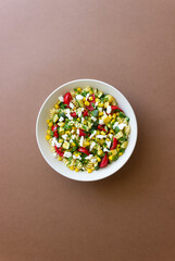 Pasta salad with tomatoes, zucchini, corn and feta cheese. Healthy eating. Vegetarian food.