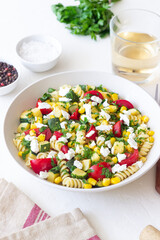 Pasta salad with tomatoes, zucchini, corn and feta cheese. Healthy eating. Vegetarian food.