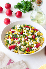 Pasta salad with tomatoes, zucchini, corn and feta cheese. Healthy eating. Vegetarian food.