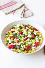 Pasta salad with tomatoes, zucchini, corn and feta cheese. Healthy eating. Vegetarian food.