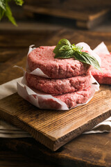Raw burger patties on wooden background