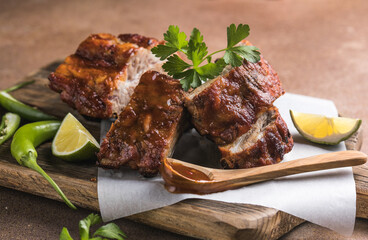 BBQ grilled ribs with vegetables on rustic table, delicious barbecue meal