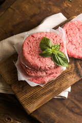 Raw burger patties on wooden background