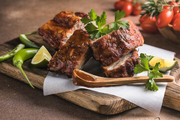 BBQ grilled ribs with vegetables on rustic table, delicious barbecue meal