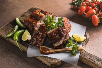 BBQ grilled ribs with vegetables on rustic table, delicious barbecue meal